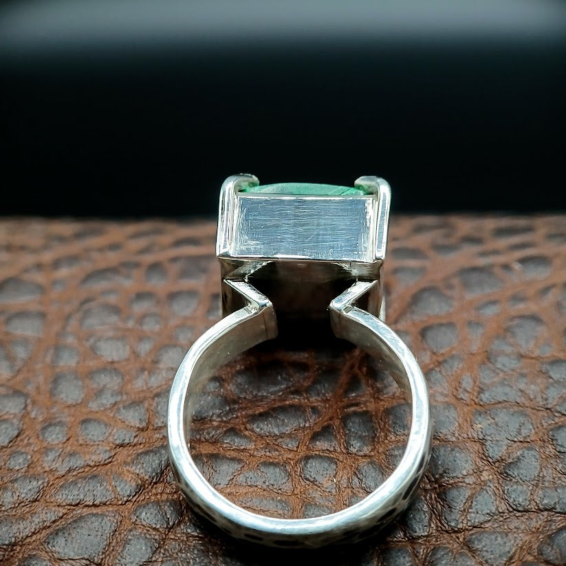Back view of silver ring on dark brown leather with dark background