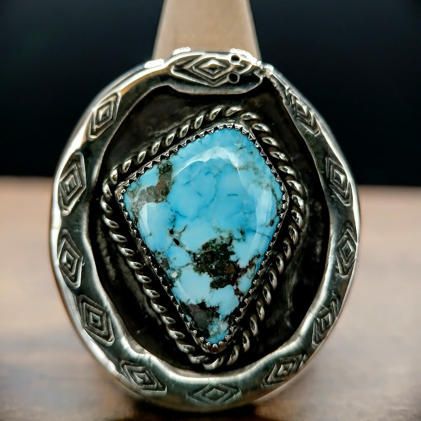 Silver ring with a turquoise stone on a dark background
