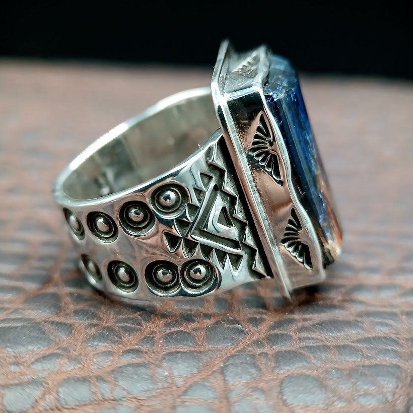 Two silver rings with intricate designs on a textured surface