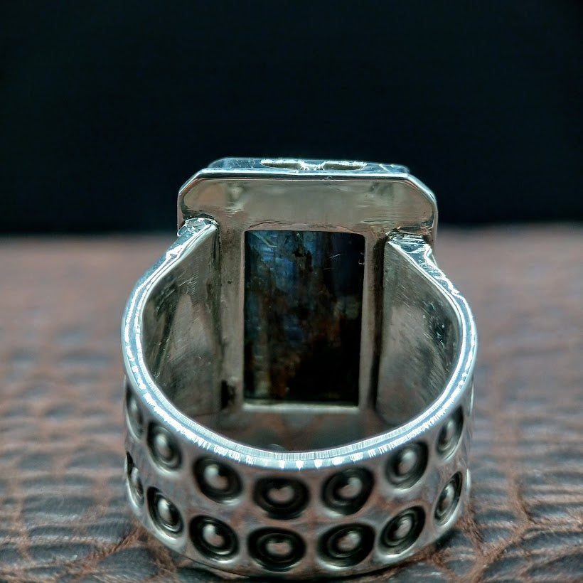 Silver ring with a textured band on a dark background