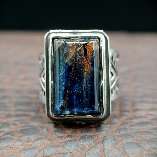 Silver ring with a rectangular blue kyanite stone on a textured surface