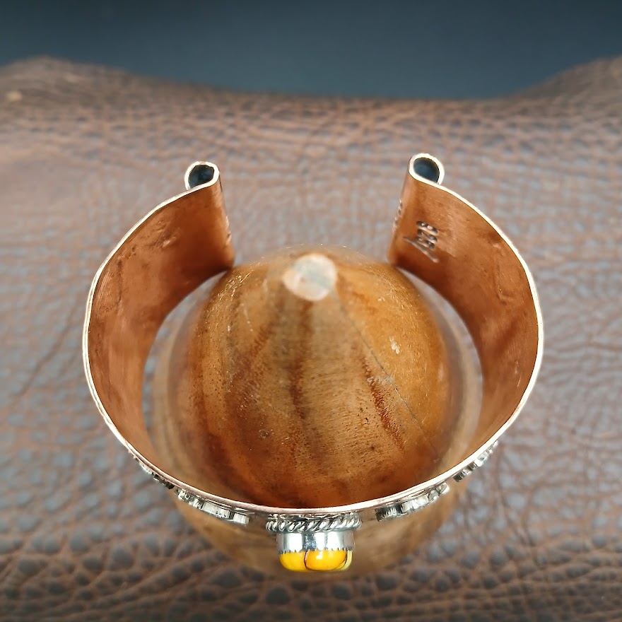 Decorative cuff bracelet on a textured wooden cone surface