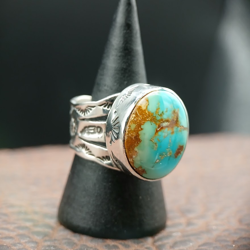 Silver ring with a turquoise stone on a black stand
