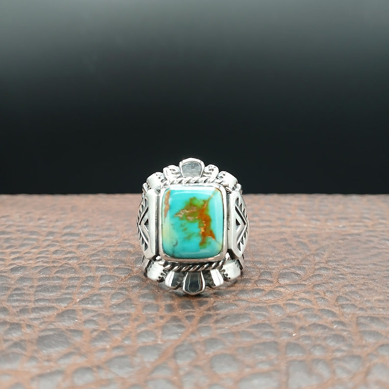 Silver ring with a turquoise stone on a textured surface
