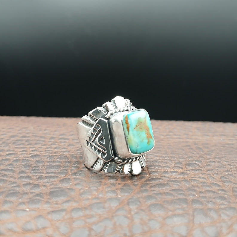 Silver ring with turquoise stone on a textured surface