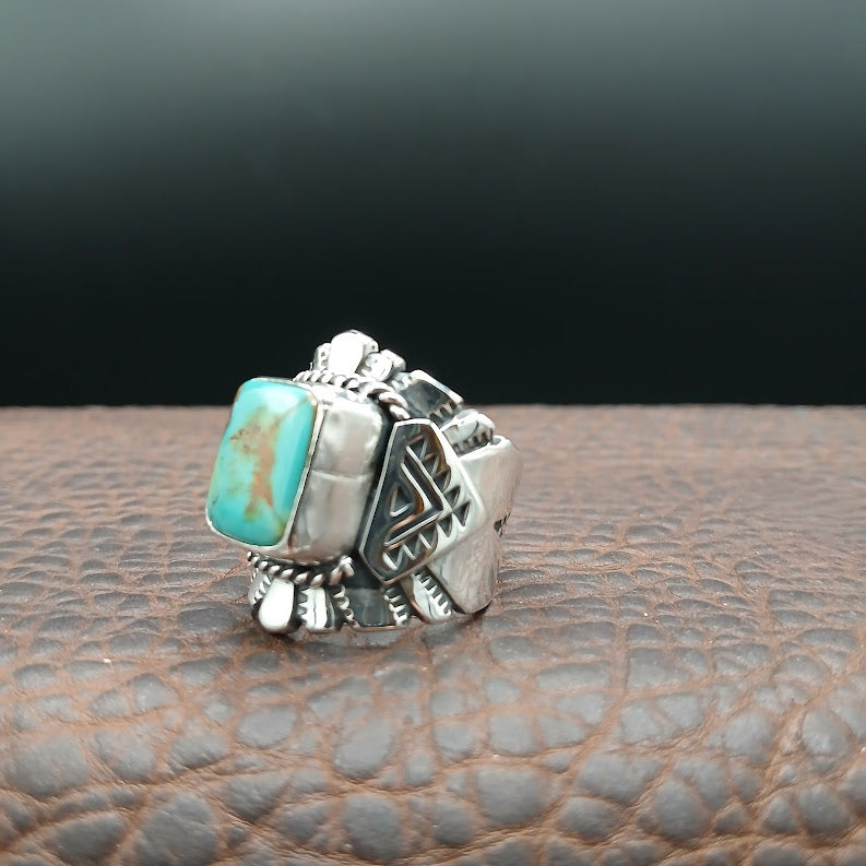 Silver ring with a turquoise stone on a textured surface