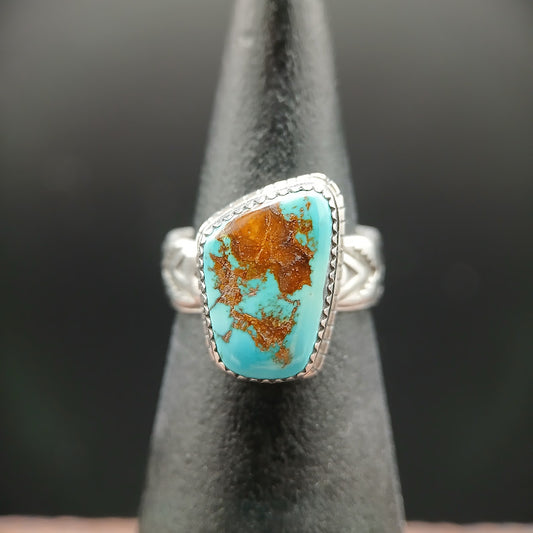 Silver ring with a turquoise stone on a black stand