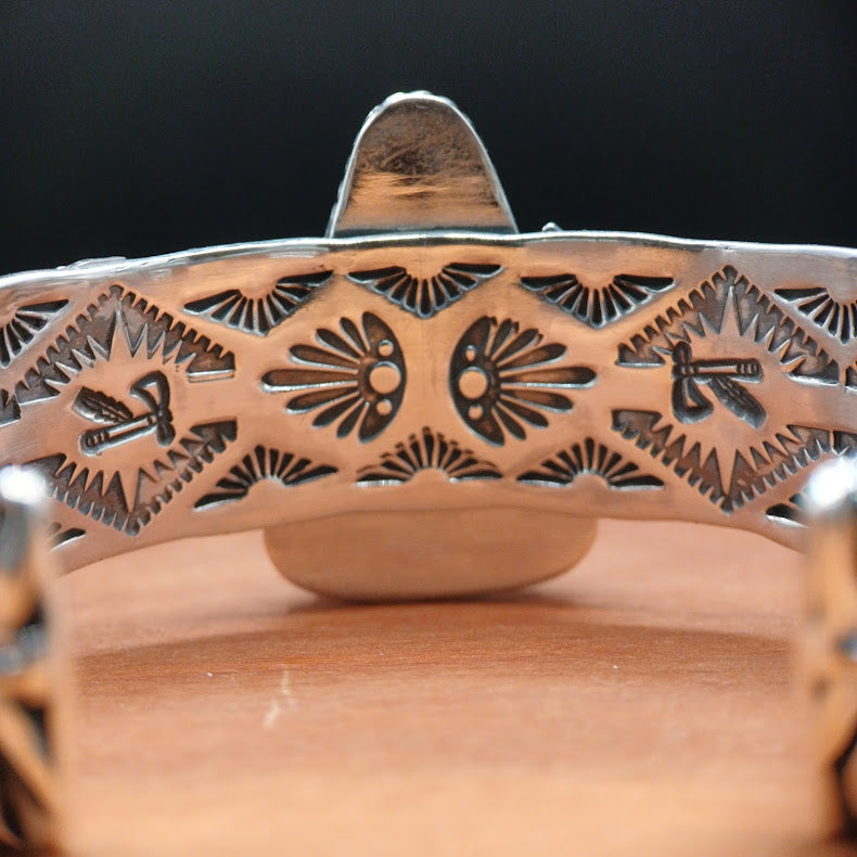 Decorative metal object with intricate patterns on a wooden surface