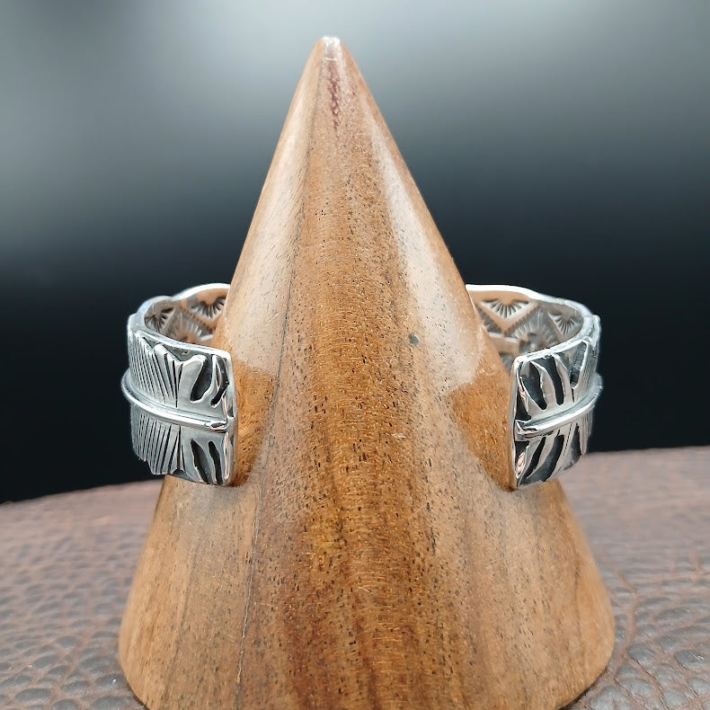 Silver bracelet on a wooden stand with a dark background