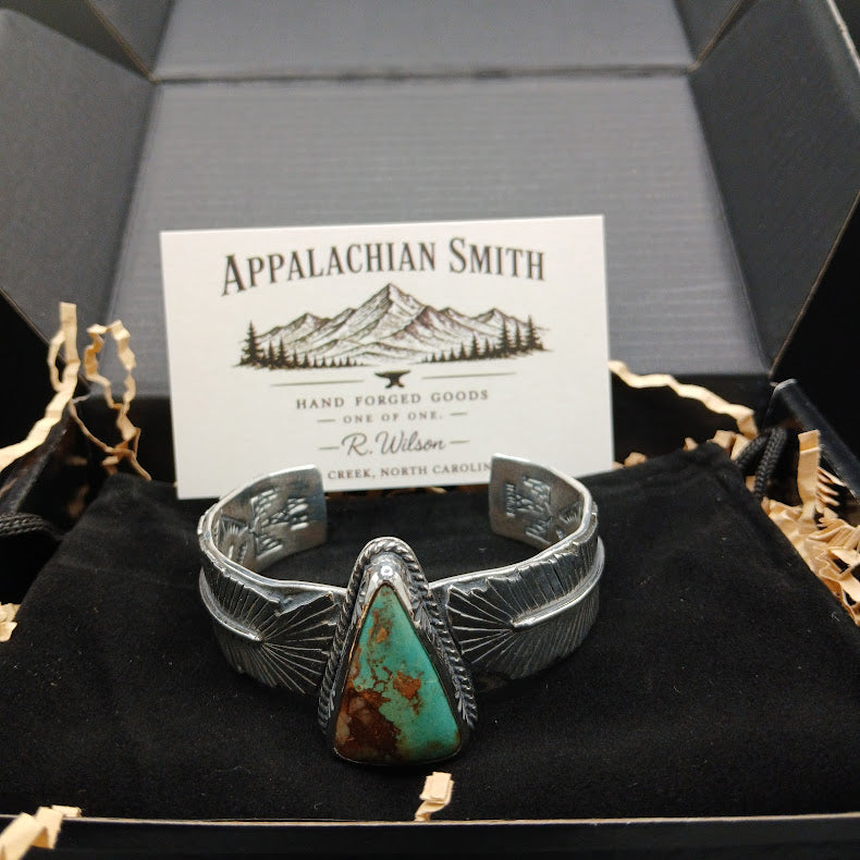 Silver bracelet with turquoise stone in a box with 'Appalachian Smith' branding.