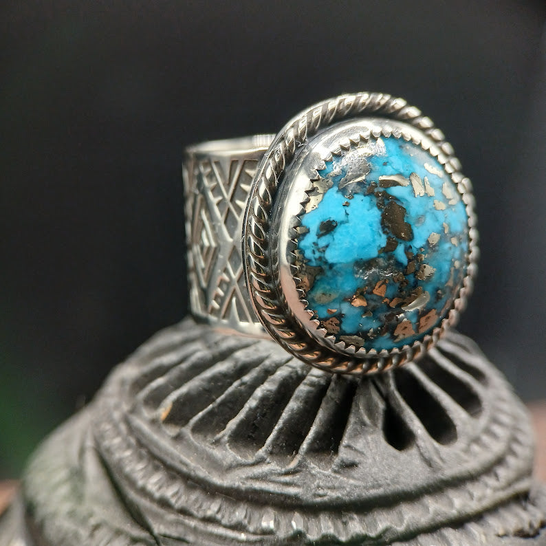 Silver ring with a turquoise stone on a dark background