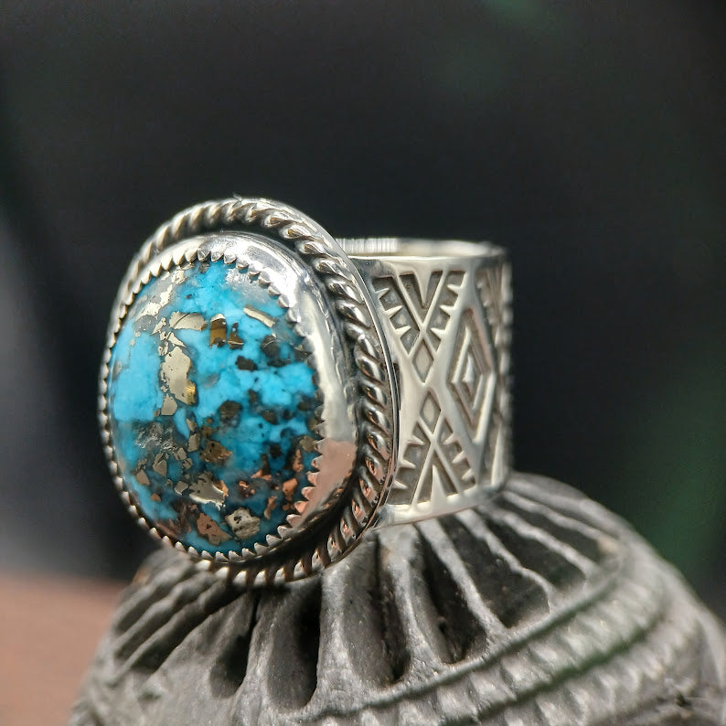 Silver ring with turquoise stone on a decorative stand