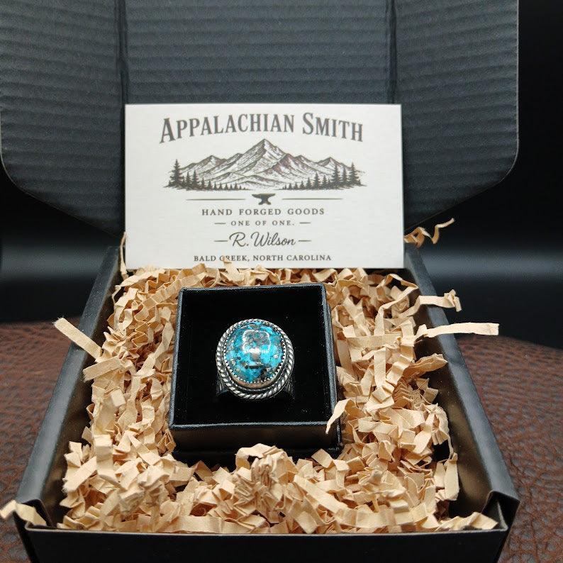 Turquoise ring in a black box with decorative paper, branded 'Appalachian Smith' on a dark background.