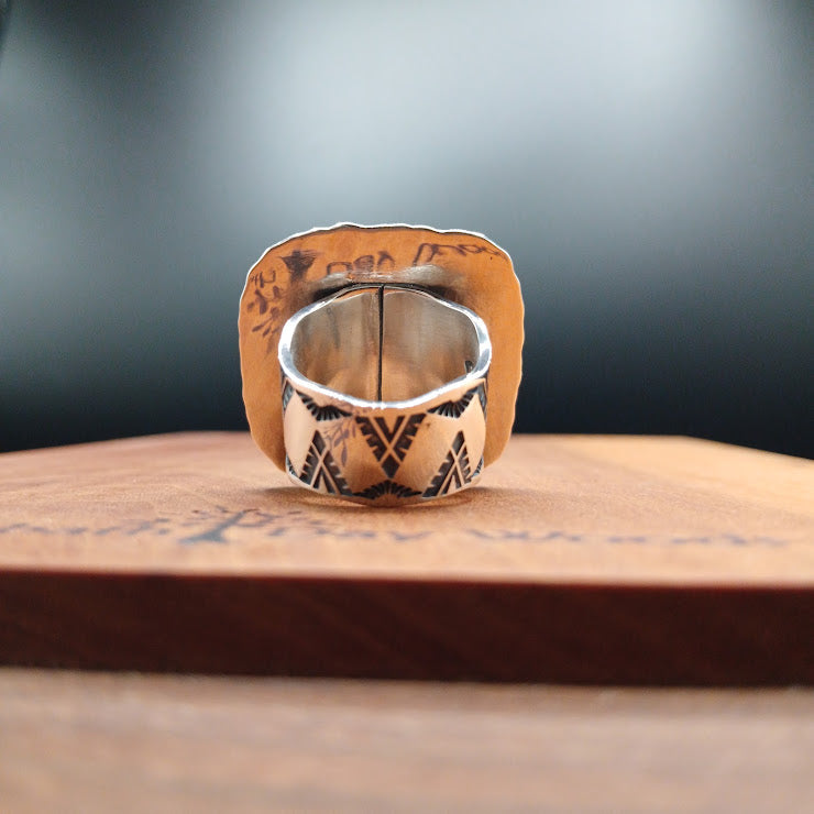 Sterling silver ring interior with RW hallmark stamp and geometric stampwork, ring on wooden display block