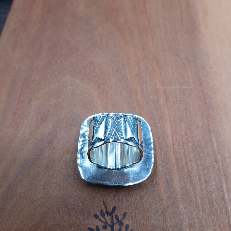 Wide sterling silver ring band with stamped geometric and thunderbird motifs, oxidized finish, hand-forged detail