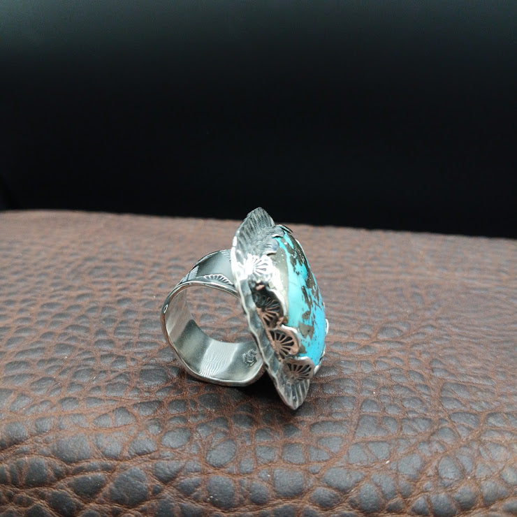 Profile view of natural turquoise cabochon in hand-serrated sterling silver bezel, showing stone depth and matrix pattern
