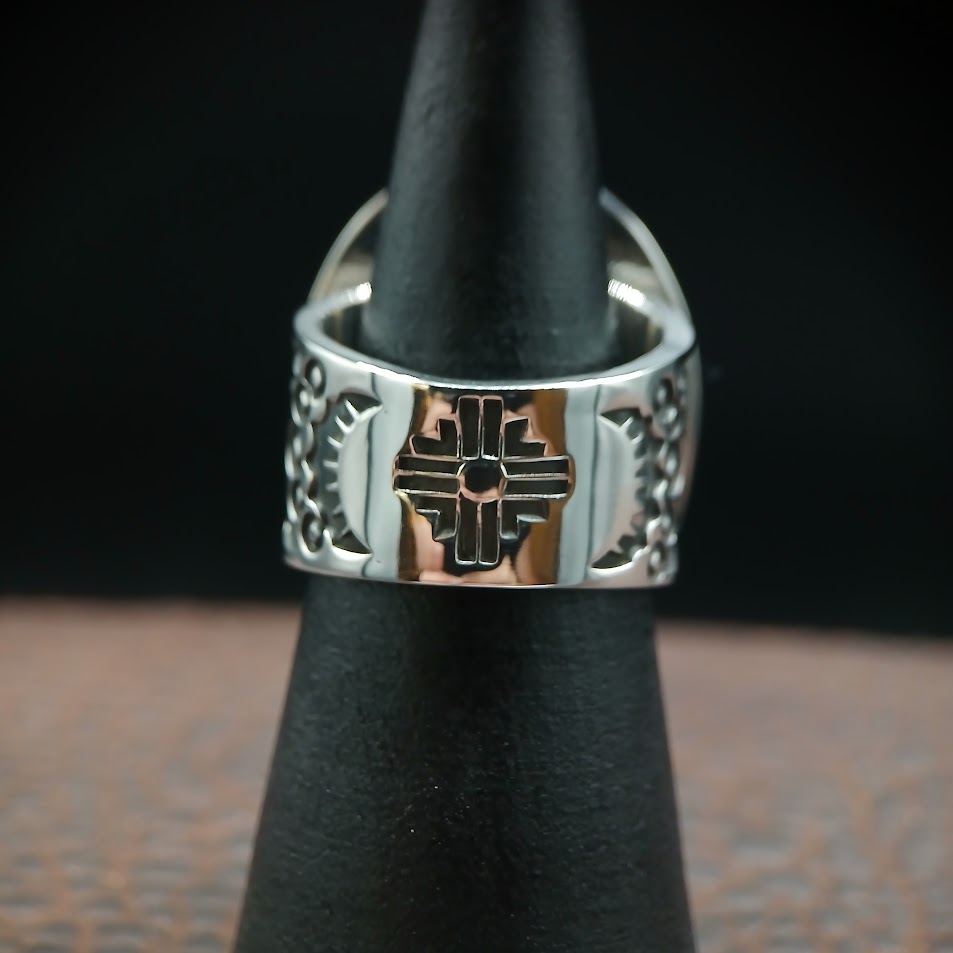Royston ribbon turquoise ring — 3/4 view showing stone and Zia sun motif shoulder, wood prop