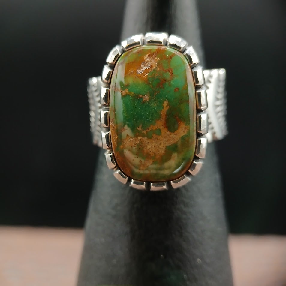 The Camelot — right profile, black cone, chevron stamp band and castellated bezel, warm light