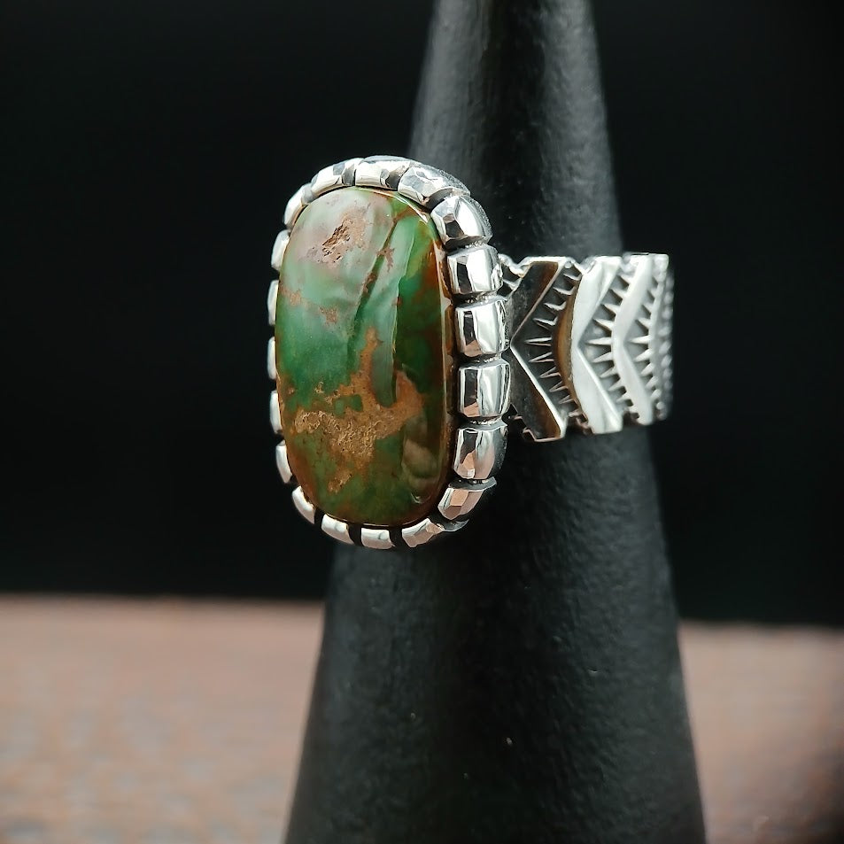 The Camelot — left profile, warm light, chevron stamps and castellated bezel